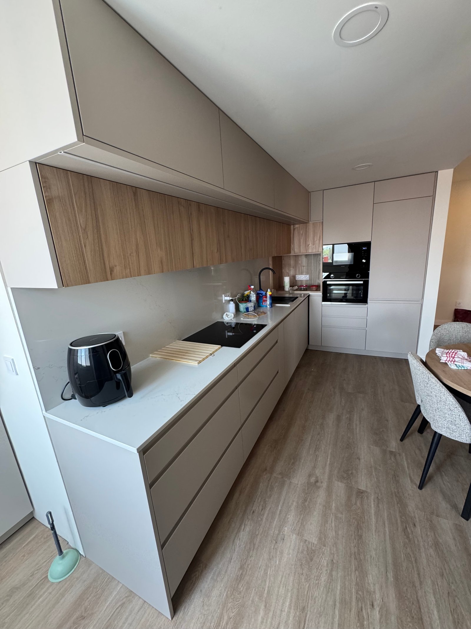 Cocina con isla y suelo imitación madera en una reforma integral en Sevilla